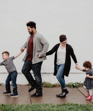 picture with two kids, man and women, holding each others hands 