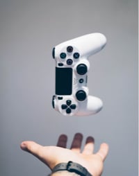 image showing left hand of person and playstation controller in the air